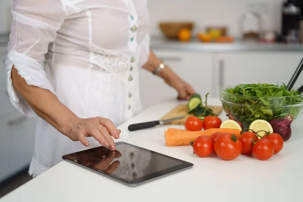 Ανώτερος γυναίκα διαβάζει συνταγή από ψηφιακό tablet — Φωτογραφία Αρχείου