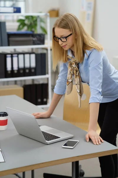 Vrouw leunt over Bureau op kantoor — Stockfoto