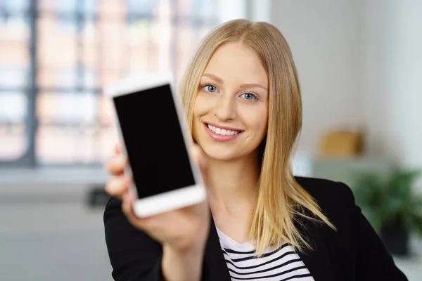 Lächelnde junge Geschäftsfrau hält ein Handy hoch — Stockfoto