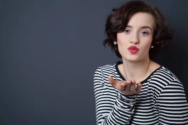 Beautiful young french woman blowing a kiss — Stock Photo, Image