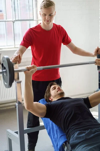 人做胸部锻炼与杠铃倾斜工作台压力机在健身房 — 图库照片