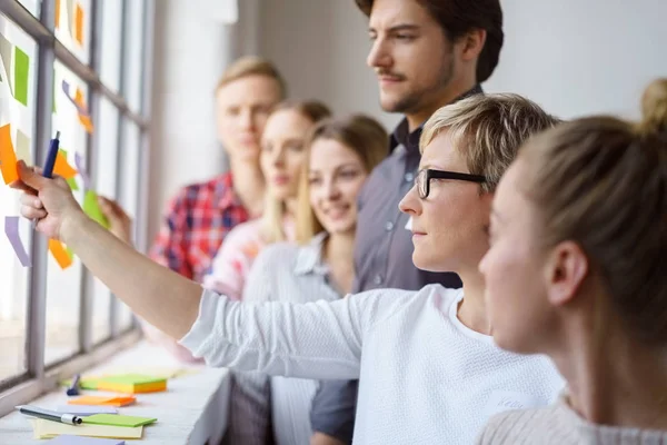 Arbetskollegor diskuterar idéer med fästisar — Stockfoto