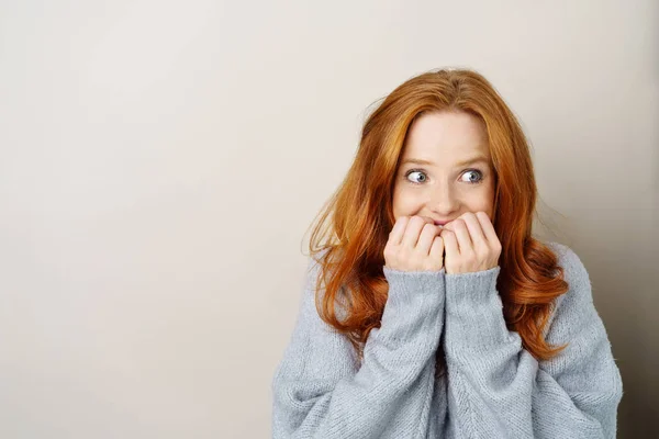 Scared young redhead woman biting her nails — Stock Photo, Image