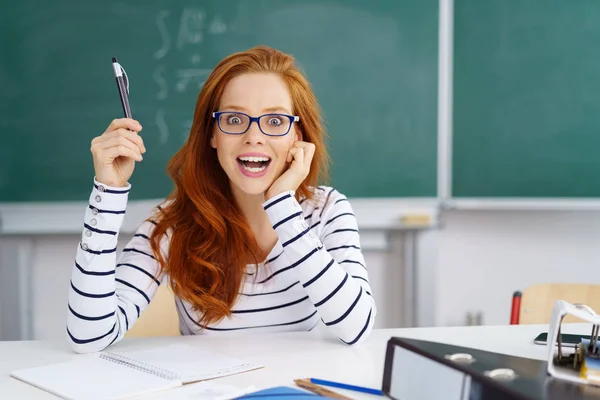 Jonge vrouwelijke leraar in de klas zitten — Stockfoto