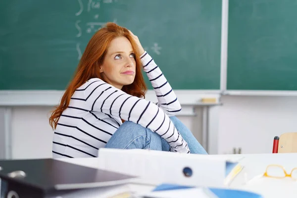 Uttråkad ung kvinna sitter i klassrummet — Stockfoto