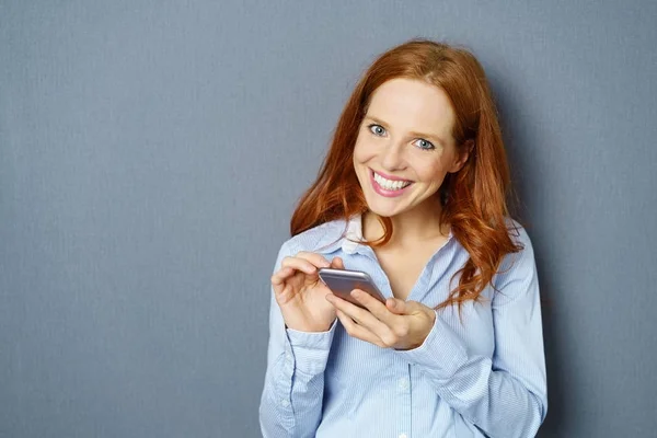 Genç kadın cep telefonuyla zencefil — Stok fotoğraf