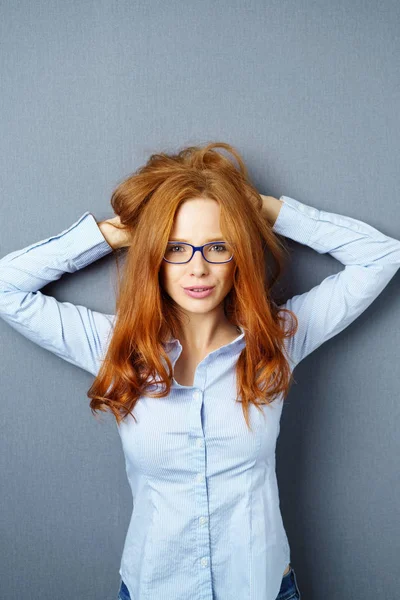 Leuke jonge vrouw die haar handen te houden aan haar haren — Stockfoto