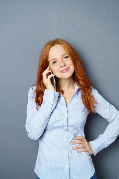Ung rødhåret kvinde taler på mobiltelefon - Stock-foto