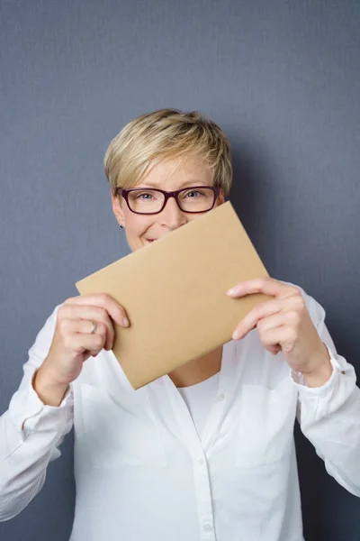 Smiling woman holding brown piece of paper — Stock Photo, Image