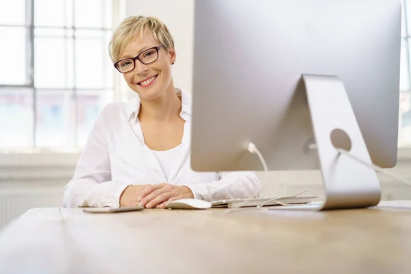컴퓨터 앞에 앉아 웃는 여자 — 스톡 사진