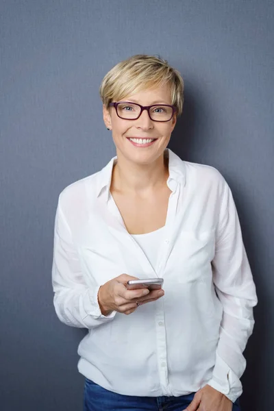 Fröhliche Frau mit Brille und Handy — Stockfoto
