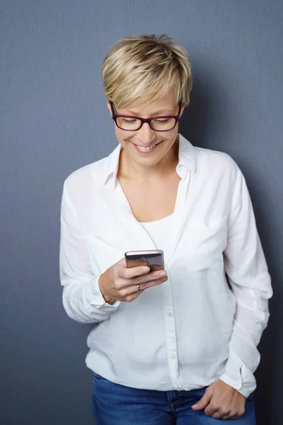 Glad ung kvinna läsa ett textmeddelande — Stockfoto