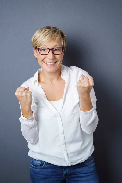 Excited young woman clenching her fists — Stock Photo, Image