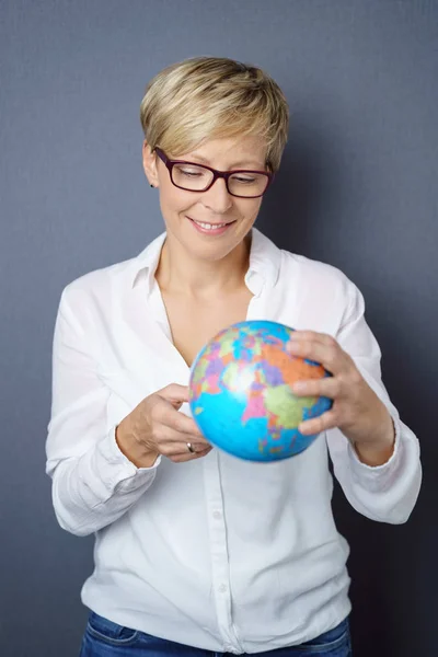Улыбающаяся молодая женщина держит глобус мира — стоковое фото