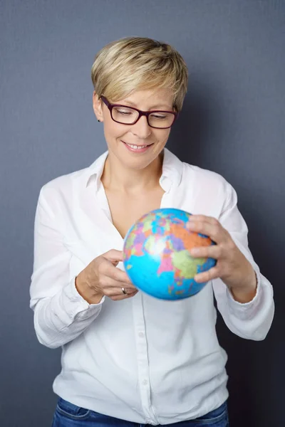 Joven sonriente sosteniendo un globo terráqueo —  Fotos de Stock