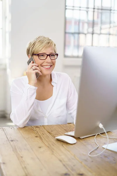 Бізнес-леді розмовляють на мобільному в офісі — стокове фото