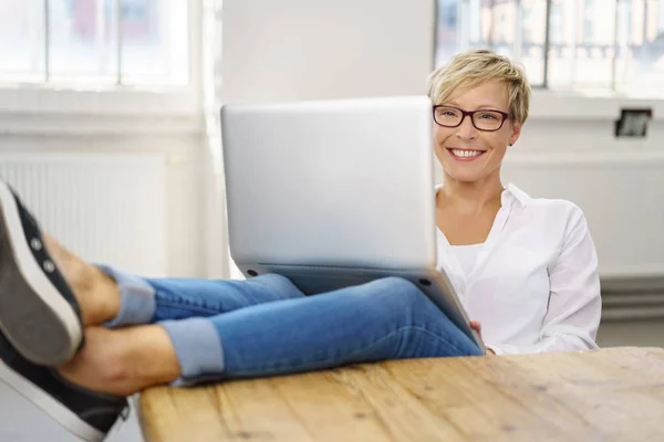 Glad ung kvinna som arbetar på sin laptop — Stockfoto