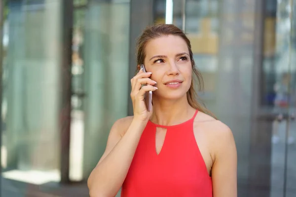 Mujer joven pensativa escuchando una llamada telefónica — Foto de Stock