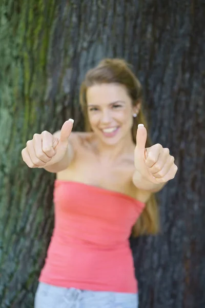 Joven mujer alegre dando pulgares hacia arriba — Foto de Stock