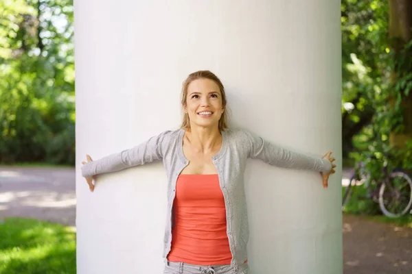 Young woman standing by column — Stock Photo, Image