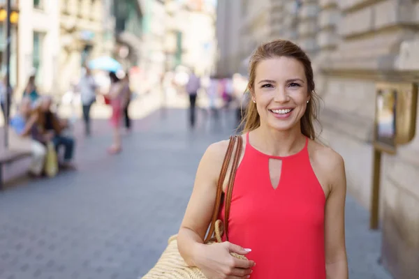 Friendly young woman walking down a street — Stock Photo, Image