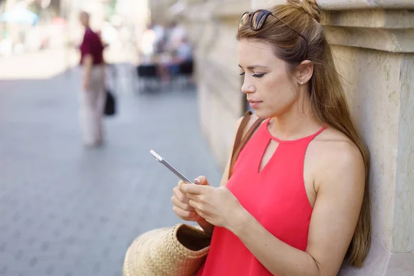 Jeune femme lisant un message texte sur son téléphone — Photo