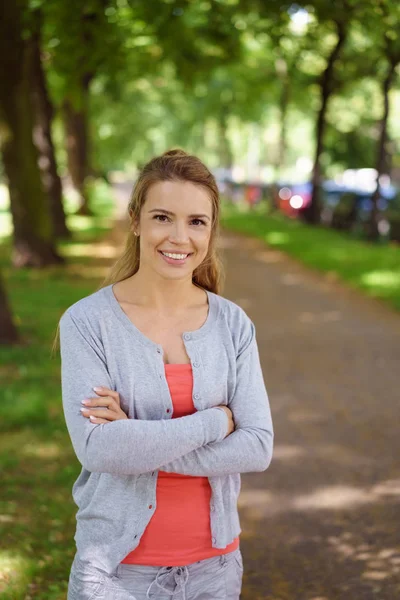 Fröhliche Frau steht im Park — Stockfoto