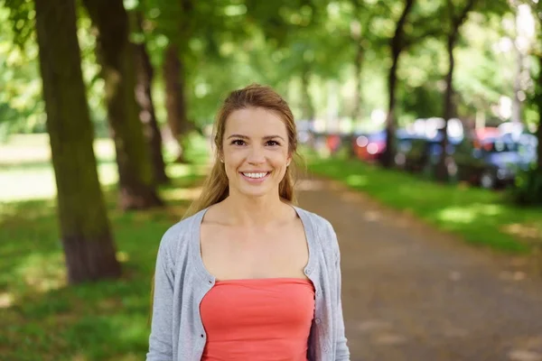 Junge Frau steht im Park — Stockfoto