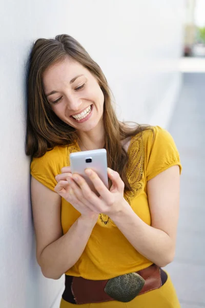Glückliche junge Frau schickt eine SMS — Stockfoto