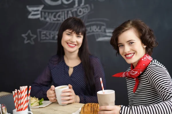Twee stijlvolle jonge vrouwen genieten van koffie — Stockfoto