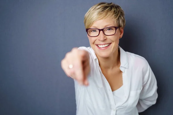 Lachende junge Frau zeigt mit dem Finger — Stockfoto