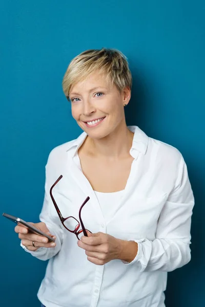 Smiling young woman holding her glasses — Stock Photo, Image