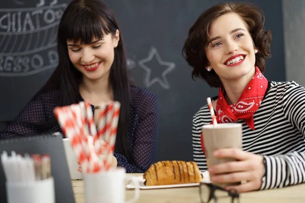 Aantrekkelijke jonge vrouw drinken koffie in een café — Stockfoto