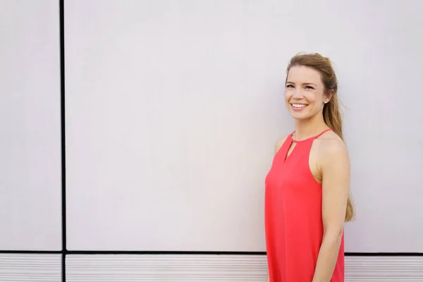 Wanita muda tersenyum mengenakan gaun merah — Stok Foto