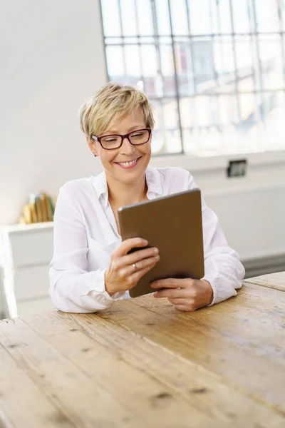 Femme blonde souriante utilisant une tablette numérique — Photo