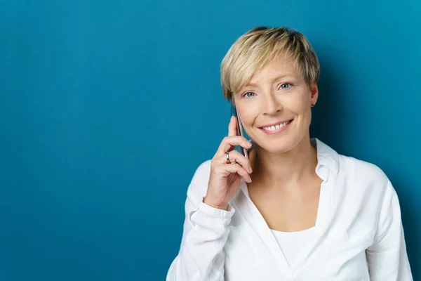 Lachende vriendelijke vrouw chatten via een mobiele — Stockfoto