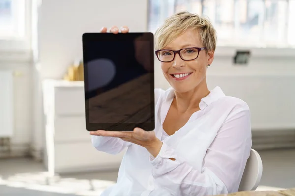 Střední dospělé blond žena držící digitální tabletu — Stock fotografie