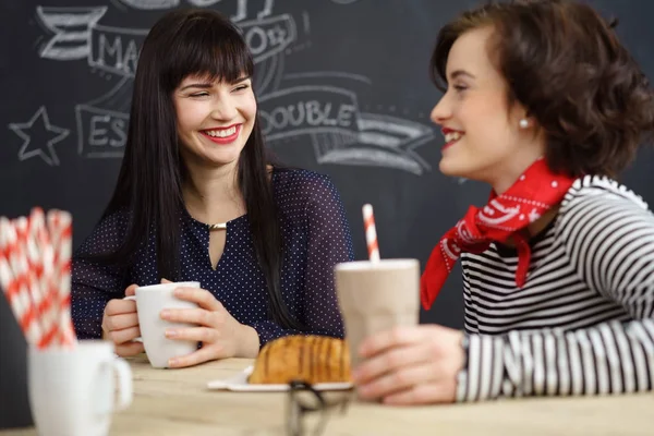 Két elegáns boldog fiatal nő birtoklás egy kávét — Stock Fotó