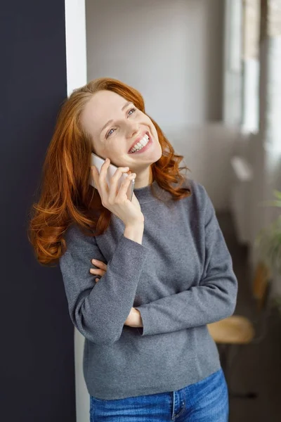 Vivacious woman grinning at a call on her mobile