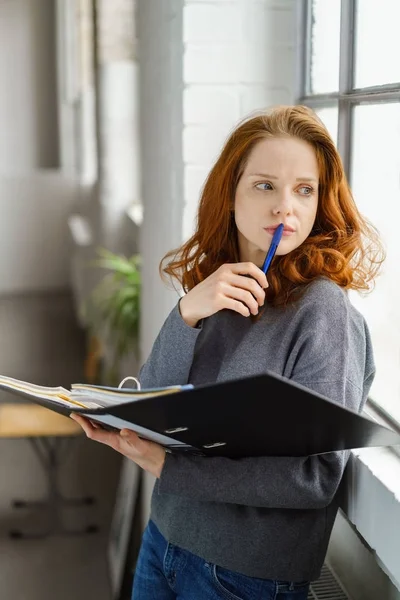 Nachdenkliche junge Studentin arbeitet an ihren Notizen — Stockfoto