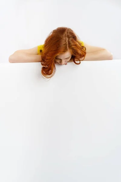 Redhead woman looking down at a blank sign — Stock Photo, Image