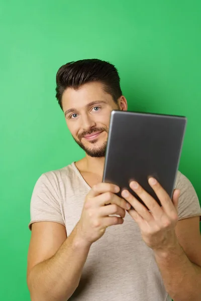 Lächelnder junger Mann mit digitalem Tablet — Stockfoto