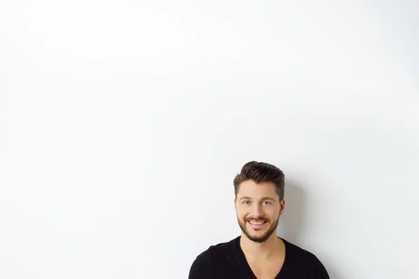 Joven hombre sonriente contra la pared blanca — Foto de Stock