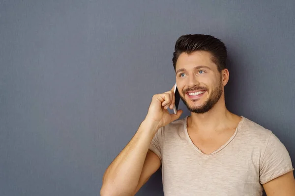 Smilende mann som lytter til en mobilsamtale – stockfoto