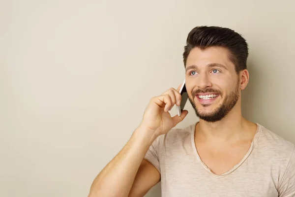 En ung skjeggete mann som snakker i telefonen. – stockfoto