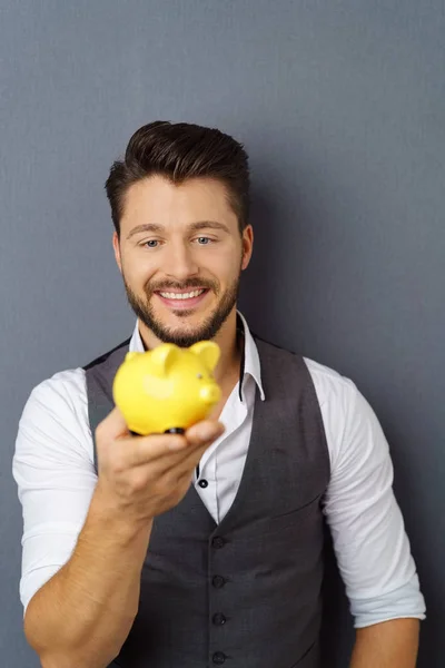 Young cheerful man holding piggy bank — Stock Photo, Image