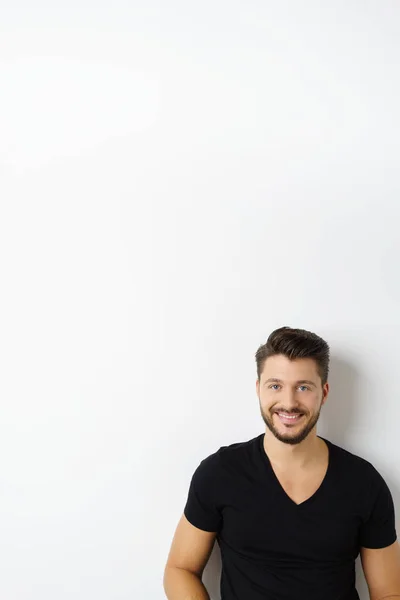 Young cheerful man against white wall — Stock Photo, Image