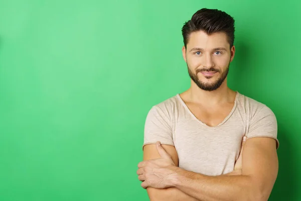 Junger Mann steht gegen grüne Wand — Stockfoto