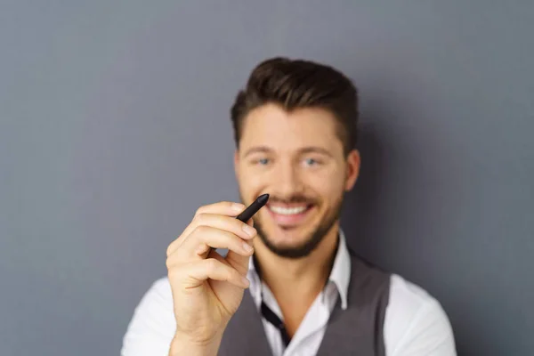 Homem barbudo alegre escrevendo no ar com caneta — Fotografia de Stock