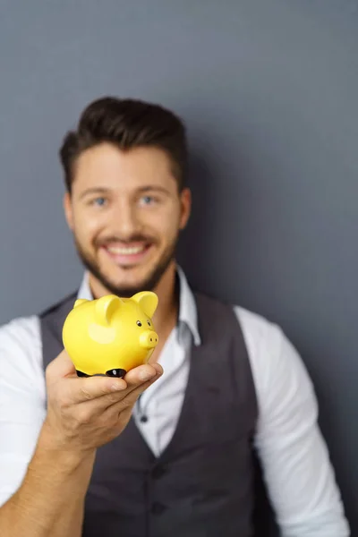 Young smiling man holding piggy bank — Stock Photo, Image